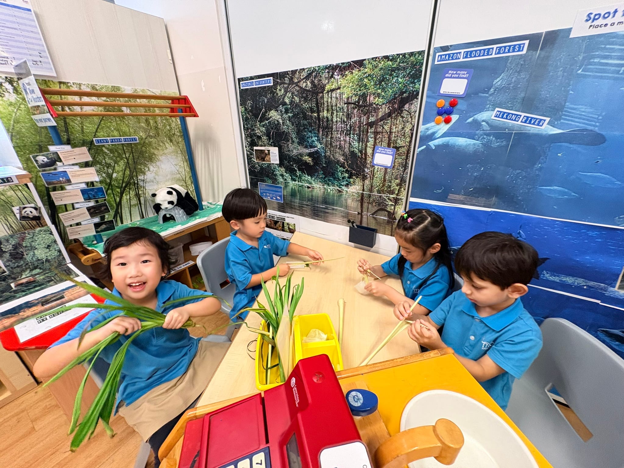 Children are exploring and making observations on pandan leaves and lemongrass while at 'Let's Find Out'.